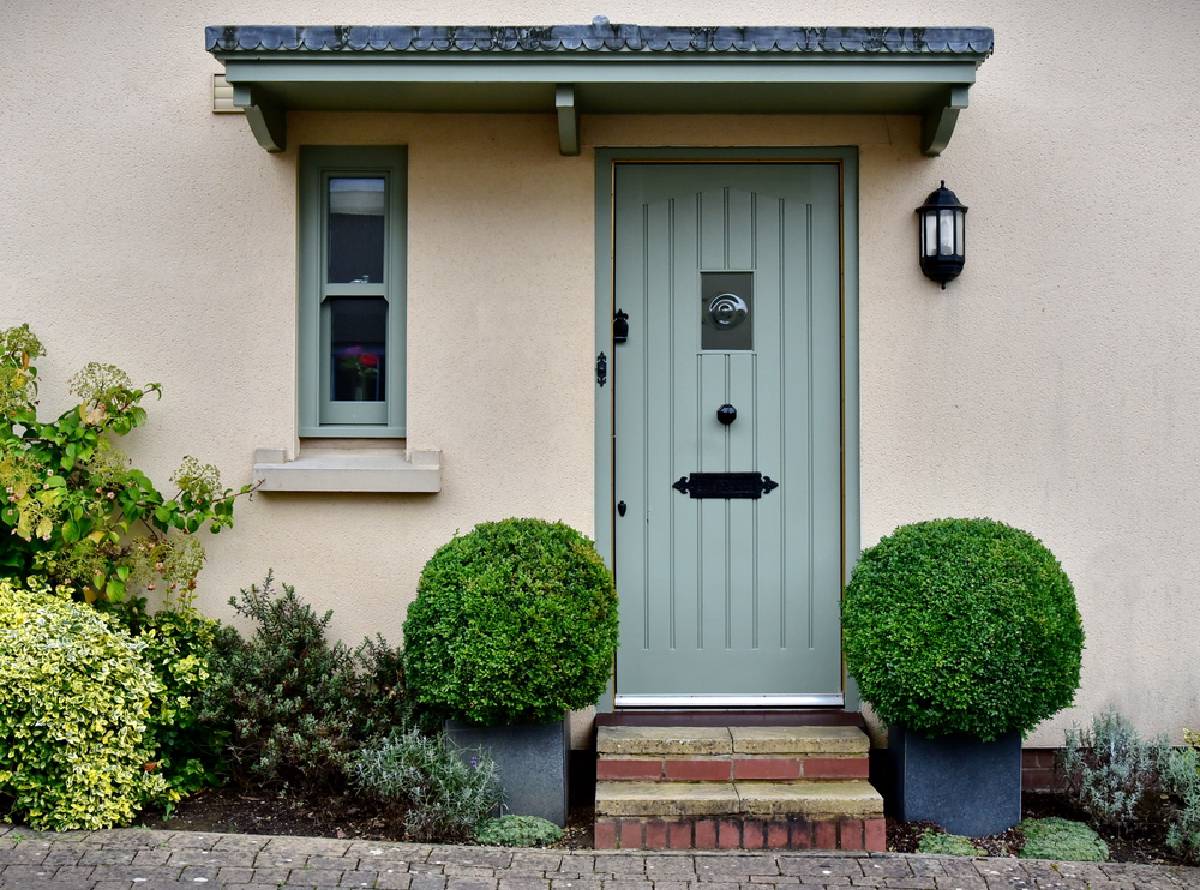 Pebbledash rendered house exterior with front door and window