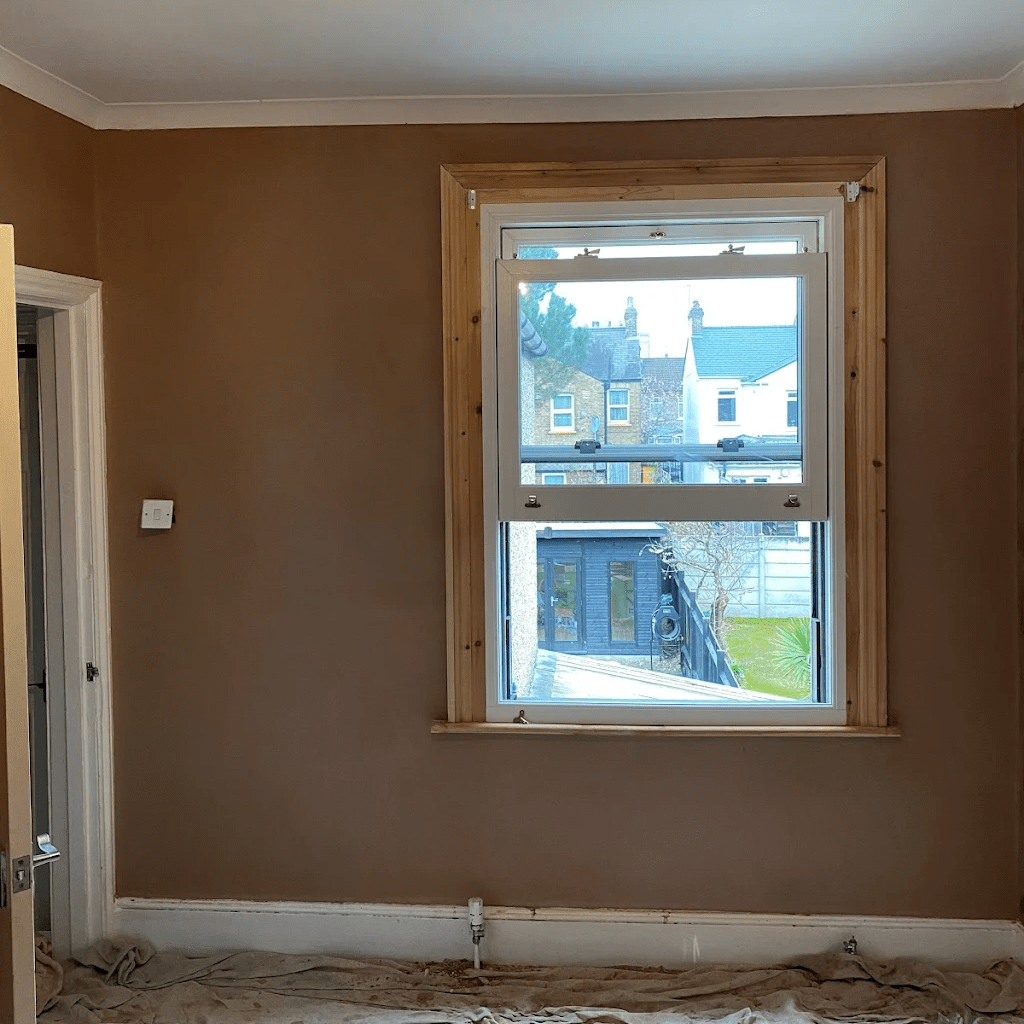 Plastered bedroom wall with newly fitted window and timber surround.
