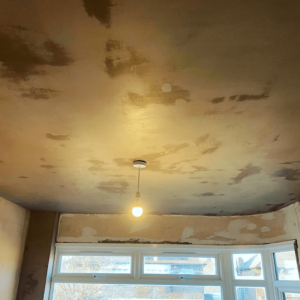 Unfinished ceiling showing plaster skimming work in progress