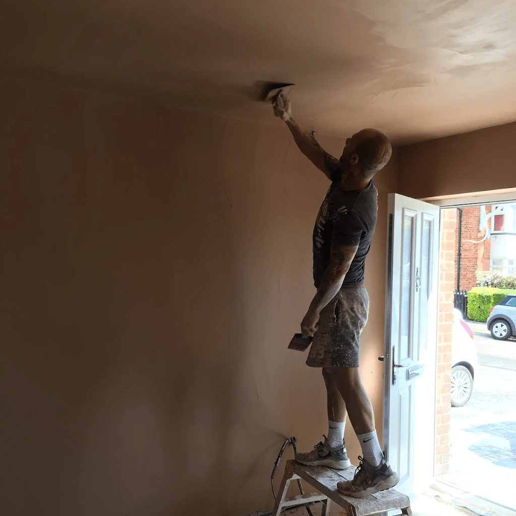 Plasterer smoothing a ceiling during interior renovation