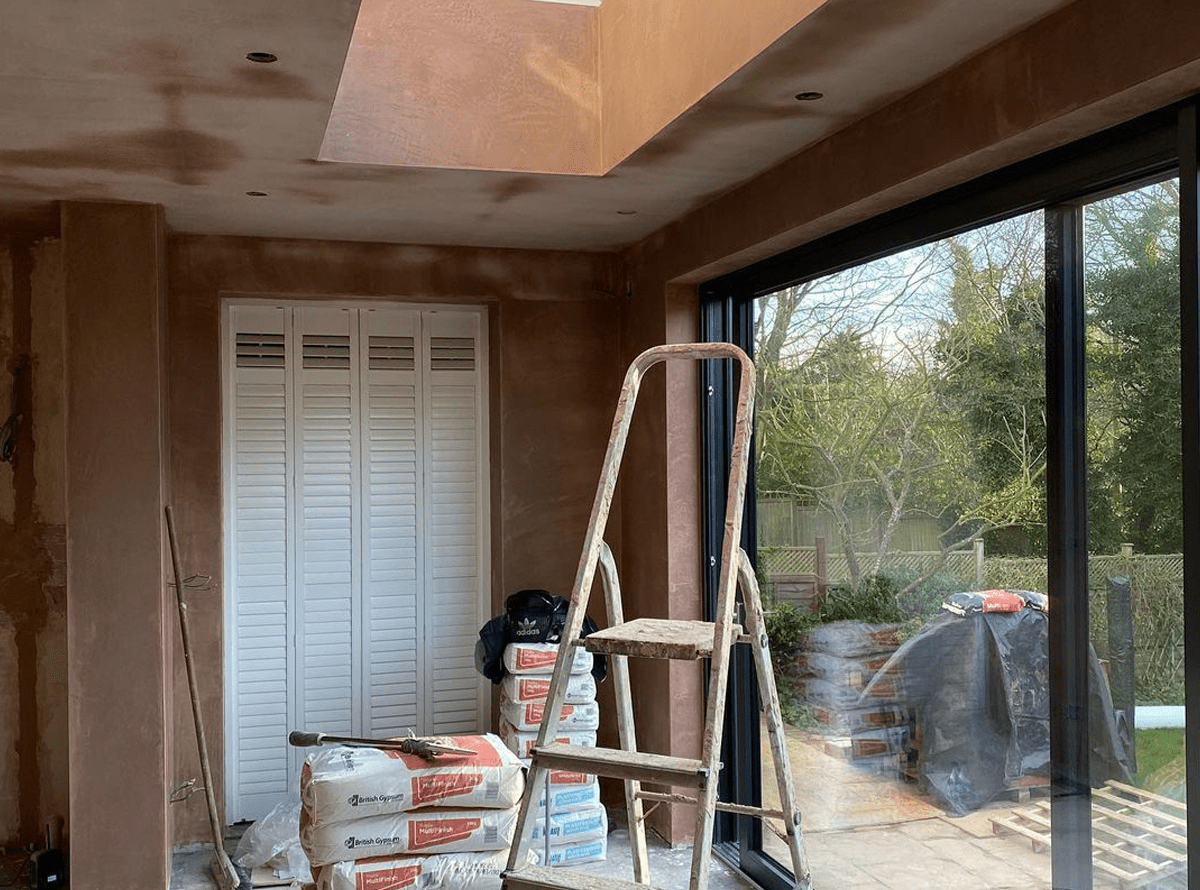 Skimming work in progress on walls and ceiling in a modern room