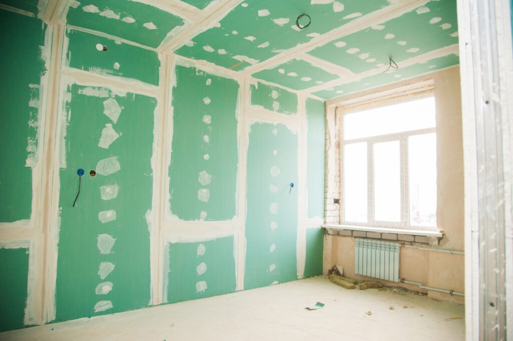 Unfinished room with plasterboard walls and ceiling awaiting plastering