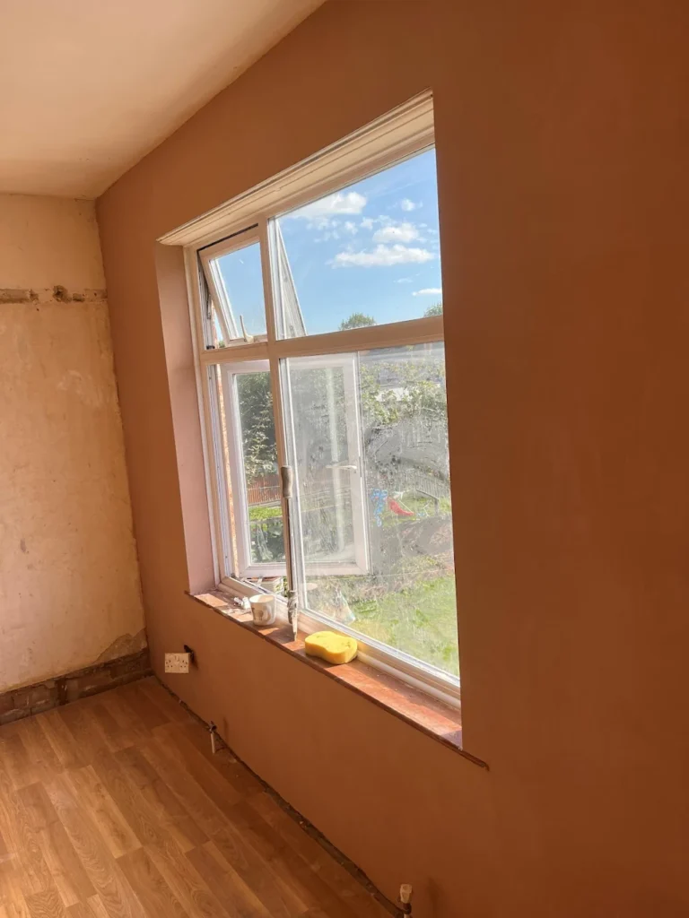 Freshly-plastered-room-with-window-and-wood-effect-flooring