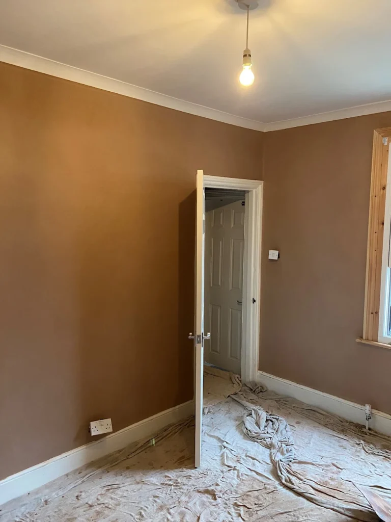 Freshly plastered room walls with a doorway and window frame