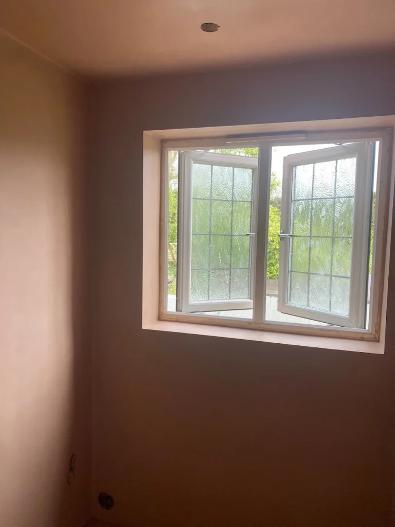 Newly plastered room with an open window and smooth finished walls